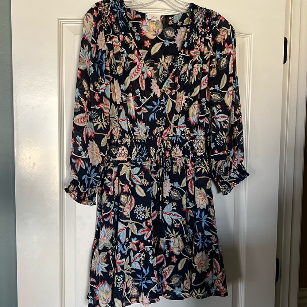 Long sleeve floral dress with button and tassel detail.